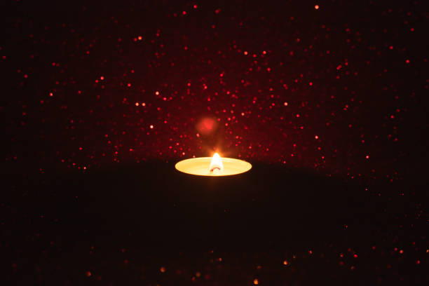 Close-up of lit candle on a red Sparkle Background
