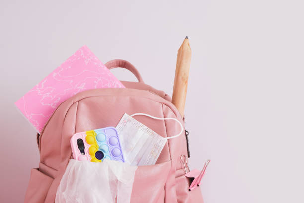 istock leather pink backpack with a head, a smartphone with a pop it case, pencil and a notebook, back to school concept 1432383123