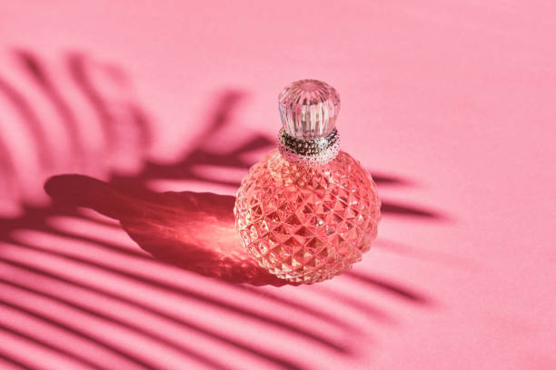 istock crystal bottle of perfume with a silver bottle on a pink background, shadow from a palm leaf, pink toilet water 1432383301