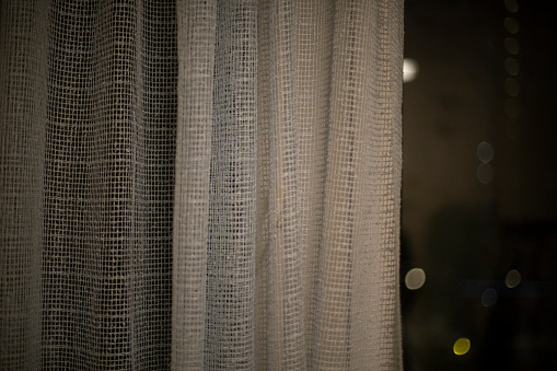 Curtains on window in evening. Fabric covers window. Interior details.