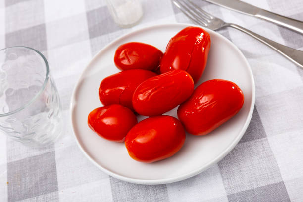 istock Canned tomatoes on white plate on wooden table 1432385948