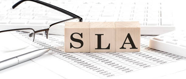 istock SLA - Service Level Agreement written on wooden cube with keyboard , calculator, chart,glasses.Business concept 1432392932