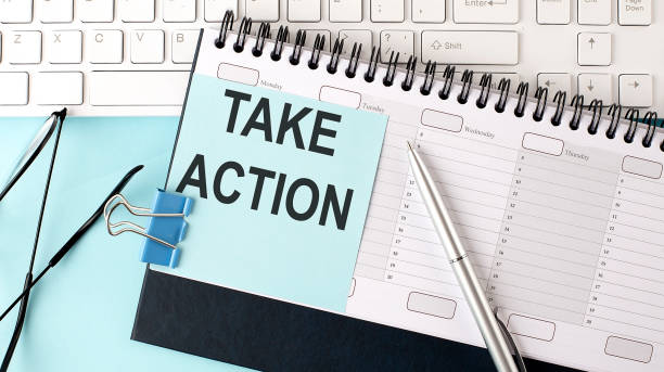 istock TAKE ACTION text on blue sticker on planning and keyboard,blue background 1432392973