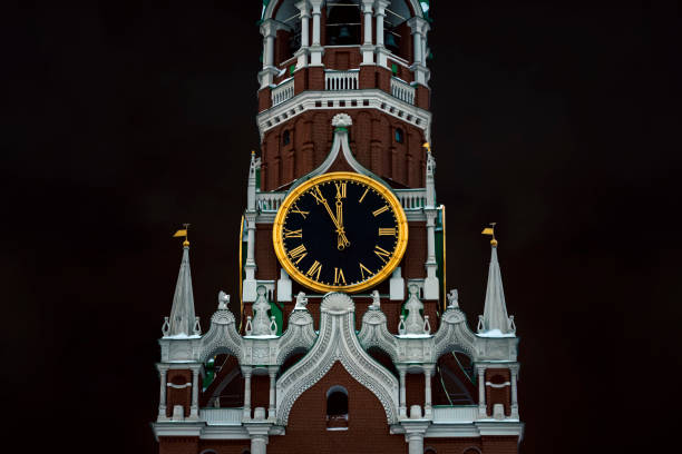 12 horas em sinos da torre spasskaya do kremlin de moscou no fundo de um céu escuro e nublado. 5 minutos até o ano novo. - spire - fotografias e filmes do acervo