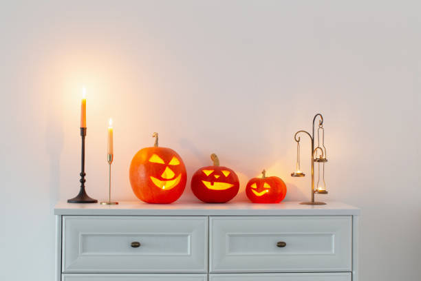 istock halloween pumpkins with burning candles in white interior 1432396283
