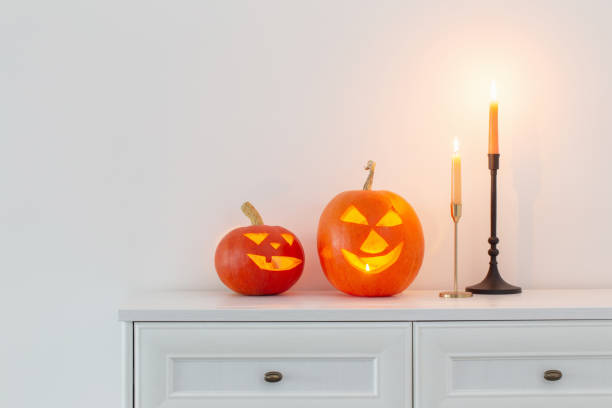 istock halloween pumpkins with burning candles in white interior 1432396285