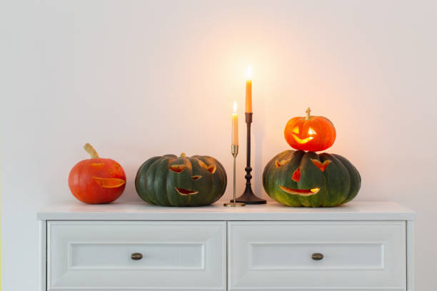 istock halloween pumpkins with burning candles in white interior 1432396287