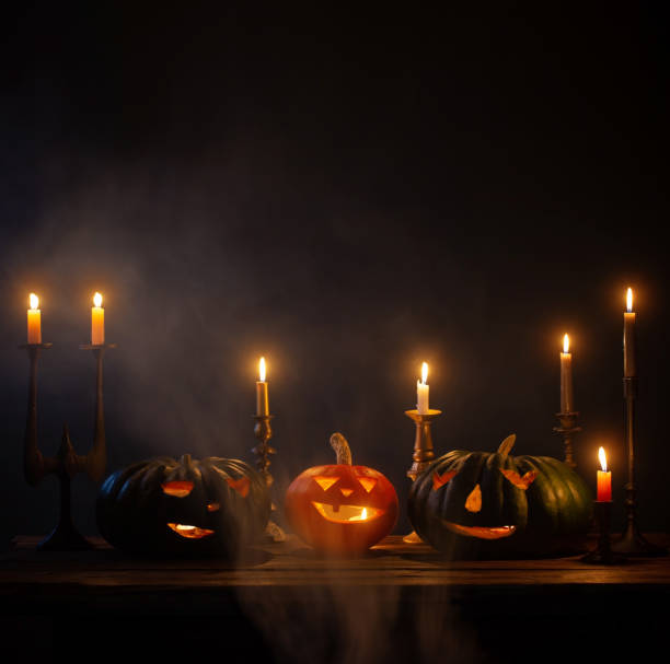 istock halloween pumpkins with burning candles on dark background 1432396294