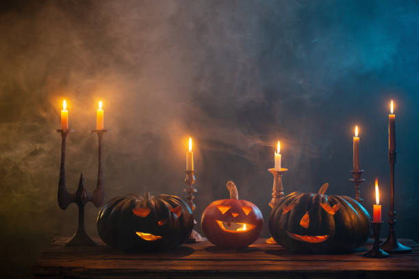 istock halloween pumpkins with burning candles on dark background 1432396304