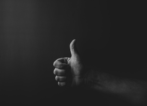 man's hand showing thumbs up