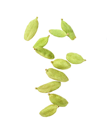 Cardamom pods levitate isolated on white background. Cardamom pods whole and chopped fly on a white background.