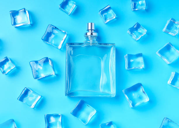 istock Empty perfume bottle lying on a frosty backdrop with ice cubes. Top view. 1432399499