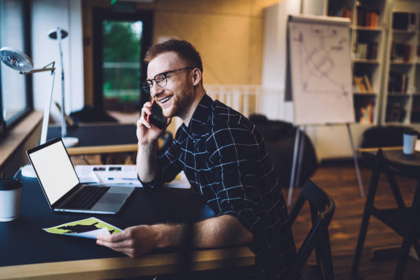 istock Cheerful freelancer with paper speaking on smartphone 1432401723