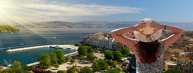 Tourism in Corfu, Greece. Back view of traveler girl enjoying view of Corfu. Conceptual image