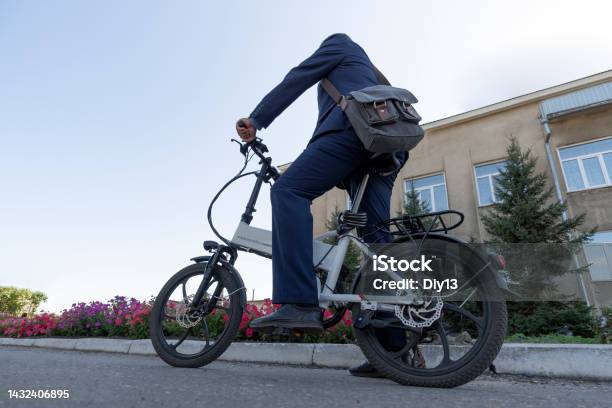 A New Modern Alternative Mode Of Transport Ecofriendly Electric Bike Hipster Businessman Commuter With Electric Bicycle Traveling To Work In City Stock Photo - Download Image Now