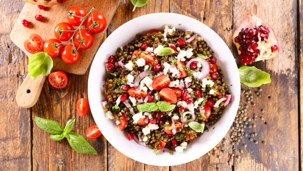 bowl of lentils salad with feta,  tomato and pomegranate stock photo