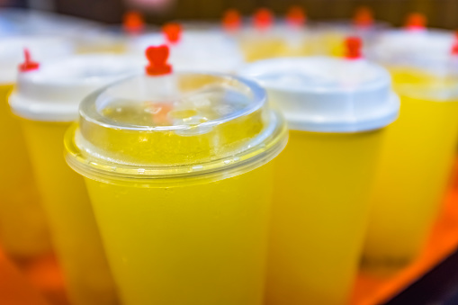 Iced orange juice drink in disposable drink cups