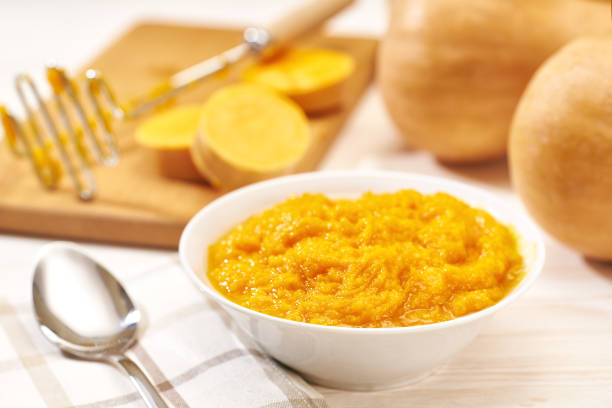 istock Pumpkin puree in a ceramic bowl, fresh pumpkin, squash, butternut close up on white kitchen table. 1432411390