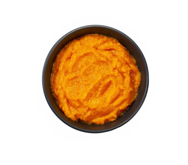 istock Pumpkin puree (mashed butternut squash) in black ceramic bow isolated on a white background. 1432411399