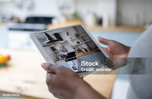 istock Woman watching the security cameras of her house using her tablet 1432413452