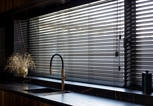 Wooden blinds black color closeup in the kitchen.