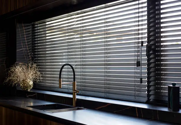 Photo of Wooden blinds black color closeup in the kitchen.