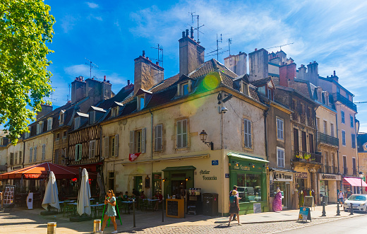 DIJON, FRANCE - AUGUST 02, 2022: Traditional architecture of old narrow streets of Dijon on sunny summer day