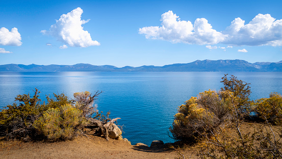 Tranquil landscape of Lake Tahoe on the dirt road footpath with clean blue water and dramatic clouds in Logan Shoals Vista Point in Nevada