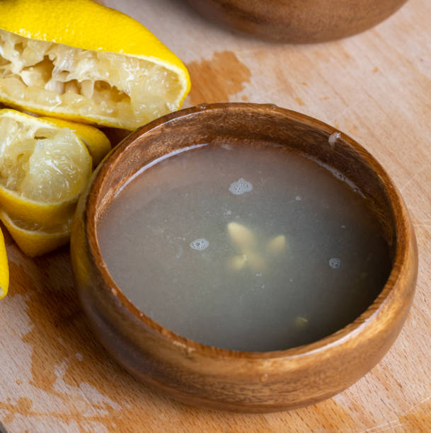 frische gelbe zitrone mit viel saft - zitronensaft stock-fotos und bilder