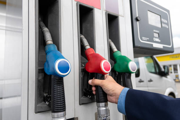 man stretching her hand to fuel nozzle with diesel, close up view - gas station gasoline refueling fuel pump imagens e fotografias de stock