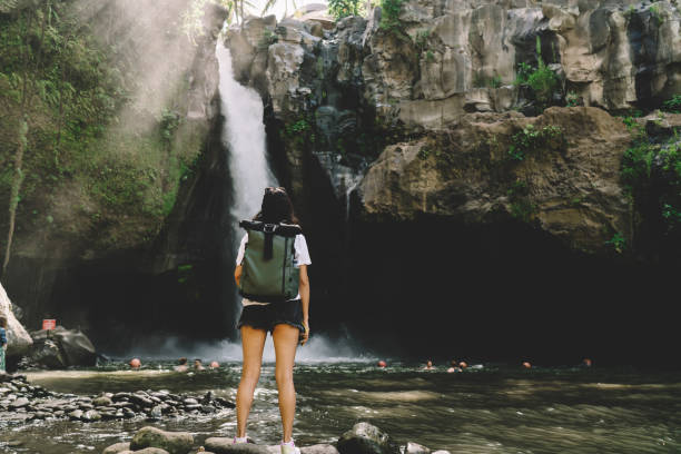 istock Trekker standing in front of big mountains and waterfall 1432421420