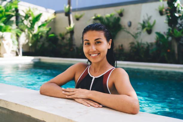 istock Delighted young lady standing in hotel swimming pool 1432421474