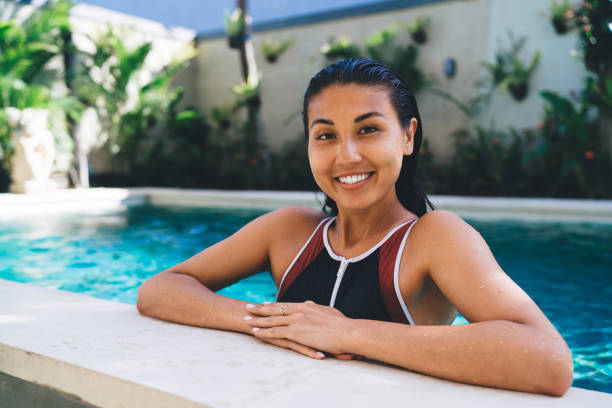 istock Positive young woman resting at poolside on sunny summer day 1432421475