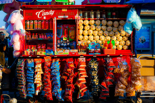 A red cart for a street vendor selling candy, chips, and other snacks on Santa Monica Pier. The pier is a popular tourist destination in Los Angeles County with amusement park rides and restaurants in addition to street vendors.