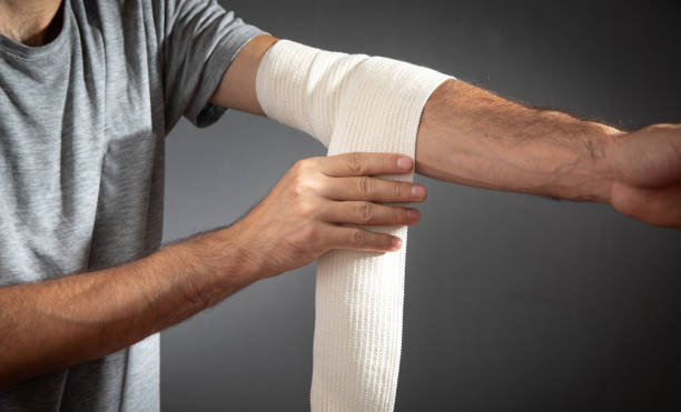istock Man bandaging an elbow. First aid and medicine concept 1432422211