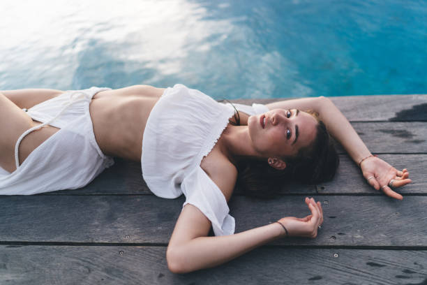 istock Graceful woman looking at camera on poolside 1432422364