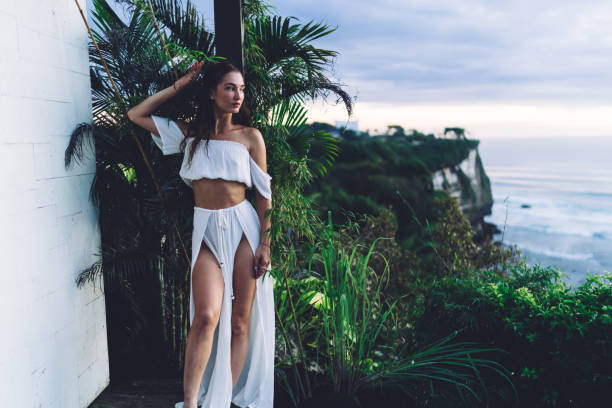 istock Young slim woman standing near exotic plants 1432422395