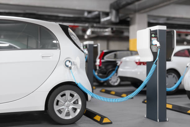 close-up view of charging electric car in parking garage. clean energy concept - electric motor fotos imagens e fotografias de stock