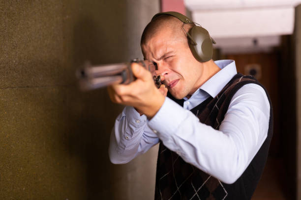 istock Focused man aiming shotgun at target in shooting range 1432424761