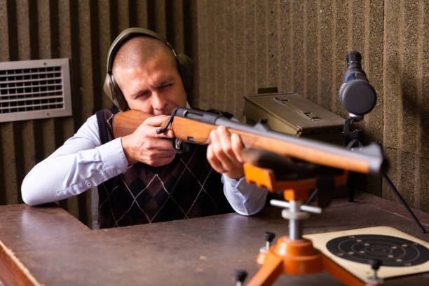 istock Man zeroing hunting rifle from bench rest in shooting range 1432424762