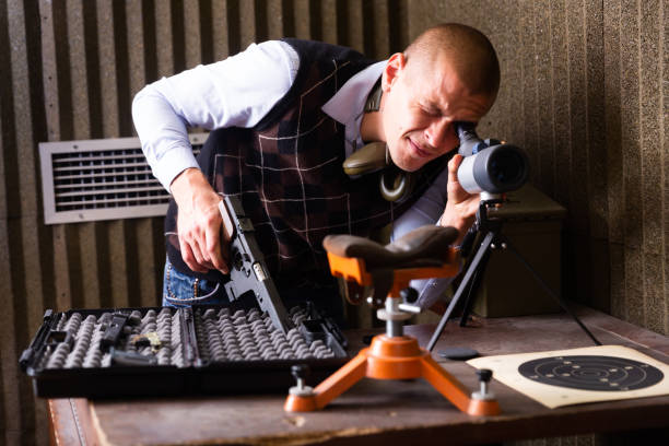istock Instructor of shooting range looks through spyglass at target 1432424774
