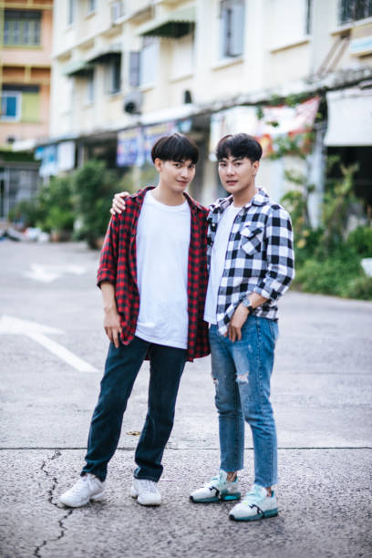istock Two loving young men in shirts and standing on the street. 1432425263