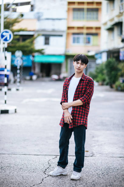 istock A young man in a striped shirt is standing on the street. 1432425264
