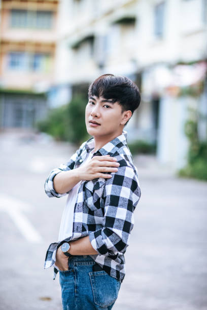 istock A young man in a striped shirt is standing on the street. 1432425375