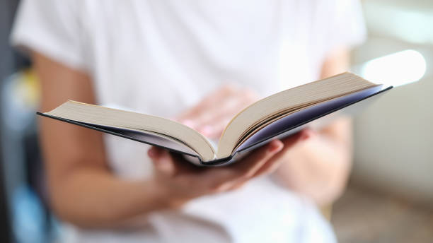 istock Woman is reading book and leafing through pages closeup 1432426127