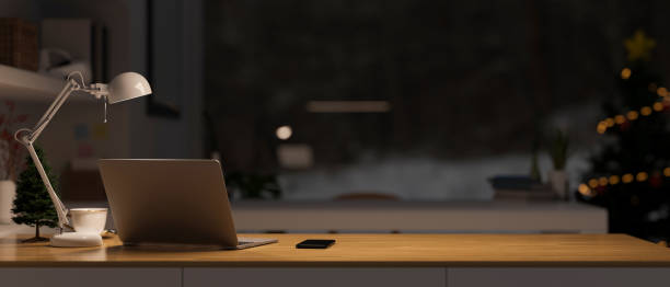 istock Modern and cozy home working space at night with copy space, laptop, table lamp, and stuff 1432426328