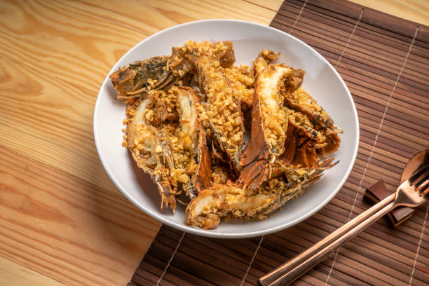 istock Stir fried flathead lobster with garlic and pepper on wooden table, Fried flathead lobster with garlic. 1432427733