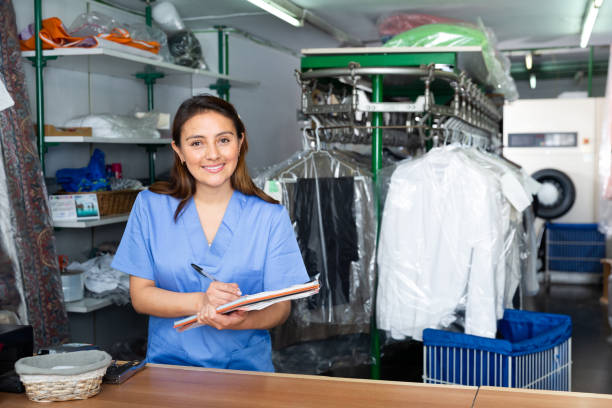 istock Woman worker of laundry writing receipt while taking clothes for cleaning 1432427998