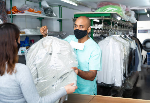 istock Man dry-cleaning worker giving clothes to customer 1432428143