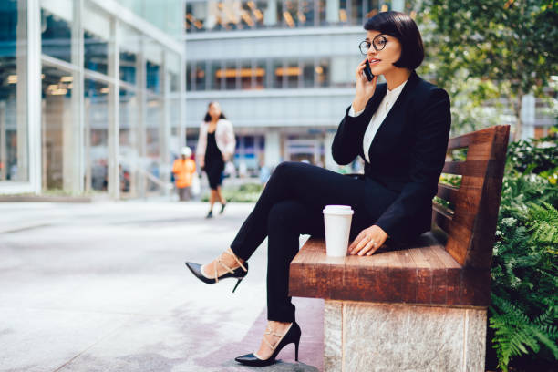 istock Elegant woman chatting on call while siting on bench 1432429328